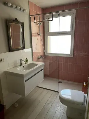 a bathroom with a sink and a toilet and a window at Modern Marina View 2 beds apt -New Marina-El Gouna in Hurghada
