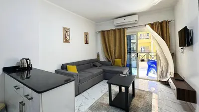 a small living room with a couch and a kitchen at LA MERA Suite in Hurghada