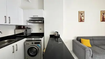 a kitchen with a washing machine and a couch at LA MERA Suite in Hurghada