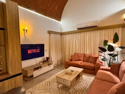 a living room with a couch and a tv at Boho 2-BDR Haven in Makadi Heights - By Kemetland in Hurghada