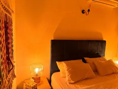a bedroom with a bed with a black headboard and a lamp at Boho 2-BDR Haven in Makadi Heights - By Kemetland in Hurghada