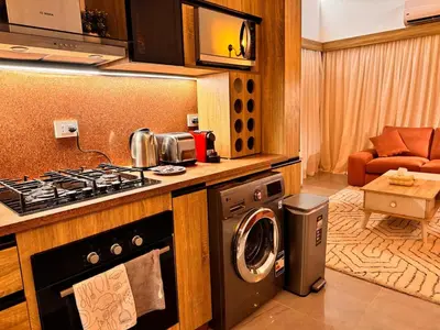 a kitchen with a stove and a washing machine at Boho 2-BDR Haven in Makadi Heights - By Kemetland in Hurghada