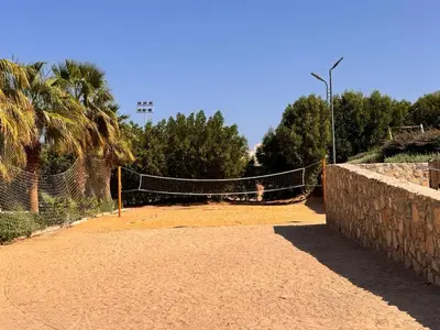 a tennis court with a net on a dirt field at Boho 2-BDR Haven in Makadi Heights - By Kemetland in Hurghada