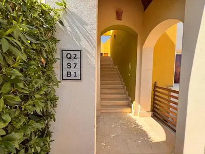 a sign on the side of a building with a staircase at Boho 2-BDR Haven in Makadi Heights - By Kemetland in Hurghada
