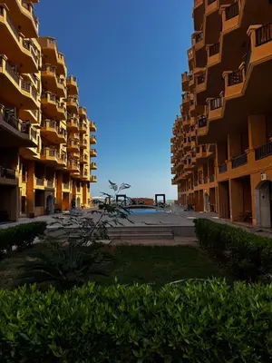 a view of two tall apartment buildings with bushes at Turtles Beach Resort Al-Ahyaa in Hurghada