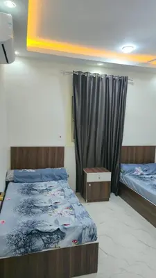 a bedroom with two beds and a curtain at البحر الاحمر الغردقه in Hurghada