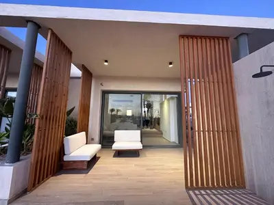 a patio with two white chairs and glass doors at Modern Minimalist Beach & Pool Side Somabay Cabana in Hurghada