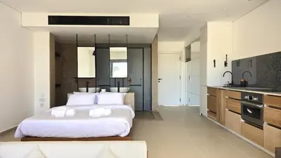 a large bedroom with two beds and a kitchen at Modern Minimalist Beach & Pool Side Somabay Cabana in Hurghada