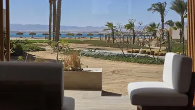 a living room with a chair and a view of the beach at Modern Minimalist Beach & Pool Side Somabay Cabana in Hurghada