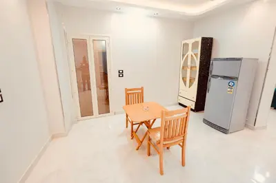 a dining room with a table and a refrigerator at signature house Luxor in Luxor
