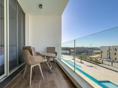 a balcony with a table and chairs and a large window at Poolside Townhome with 2 Masters, a Huge Terrace in El Gouna in Hurghada