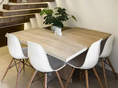 a wooden table with four white chairs and a potted plant at Poolside Townhome with 2 Masters, a Huge Terrace in El Gouna in Hurghada