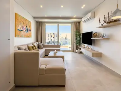 a living room with a couch and a tv at Poolside Townhome with 2 Masters, a Huge Terrace in El Gouna in Hurghada