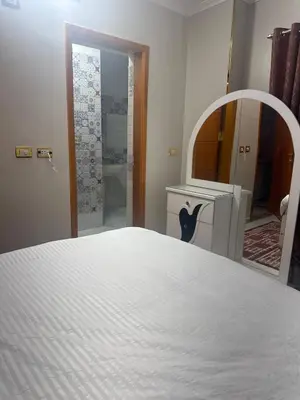 a bedroom with a white bed and a mirror at King tut 7 in Aswān