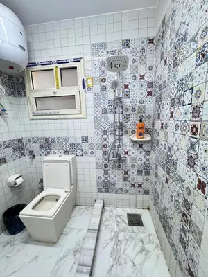 a bathroom with a toilet and tiles on the wall at King tut 7 in Aswān
