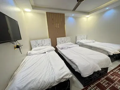 a room with two beds and a flat screen tv at King tut 7 in Aswān
