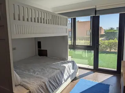 a bedroom with a bunk bed and a large window at 2BR Pool Front Soma bay Villa Near Mesca Beach in Hurghada