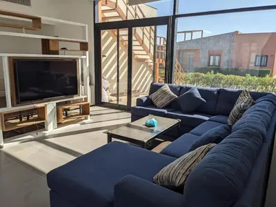 a living room with a blue couch and a tv at 2BR Pool Front Soma bay Villa Near Mesca Beach in Hurghada