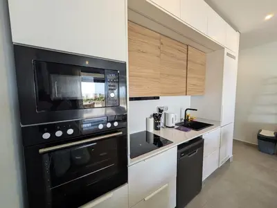 a kitchen with a microwave and a black appliance at Spacious 3BR Apartment Glorious Panoramic Seaviews in Hurghada