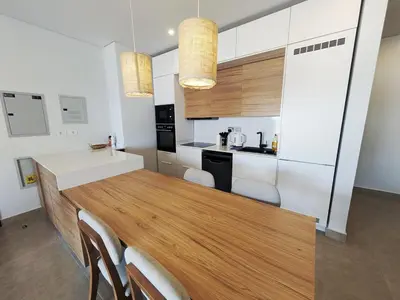 a kitchen with a large wooden table and chairs at Spacious 3BR Apartment Glorious Panoramic Seaviews in Hurghada