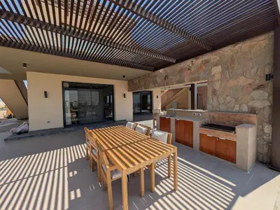 a patio with a wooden table and a kitchen at Spacious 3BR Apartment Glorious Panoramic Seaviews in Hurghada