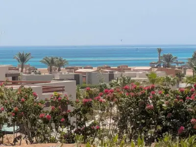 a view of the beach from a resort with flowers at Spacious 3BR Apartment Glorious Panoramic Seaviews in Hurghada