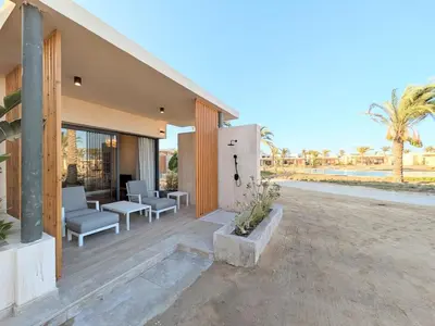 a porch of a house with chairs and tables at Beachy Pool side Mesca Cabana Somabay Steps to Sea in Hurghada