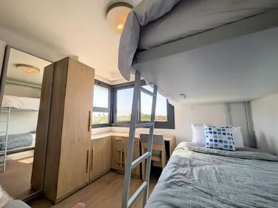 a bedroom with two bunk beds and a desk at Beautiful 2BR Mesca Beach Front Loft in Soma bay in Hurghada