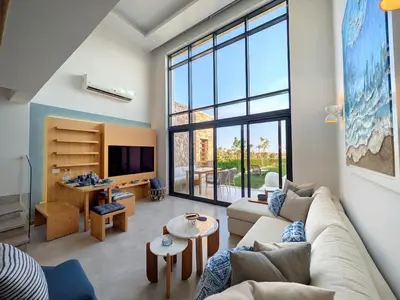 a living room with a couch and a large window at Beautiful 2BR Mesca Beach Front Loft in Soma bay in Hurghada
