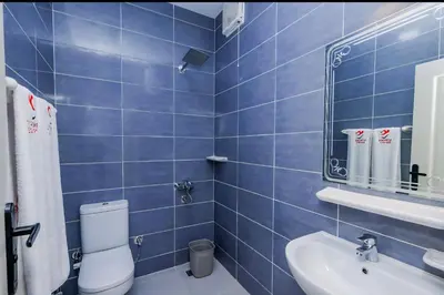 a blue tiled bathroom with a toilet and a sink at Aquatic Village - Red Sea Resort in Hurghada