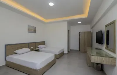 a hotel room with two beds and a television at Aquatic Village - Red Sea Resort in Hurghada