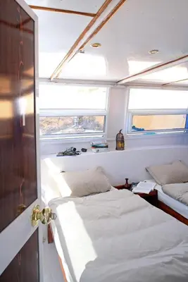 a bedroom with two beds and two windows on a boat at Nubiana Boat