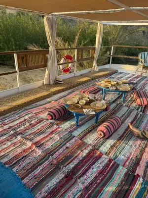 a table with a rug on top of a patio at Nubiana Boat
