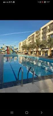 a large swimming pool with blue water and buildings at الغردقه قريه فنادير باى in Hurghada