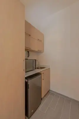 a kitchen with a stainless steel refrigerator and cabinets at Dreamy Studio in Bali Compound, El Gouna in Hurghada