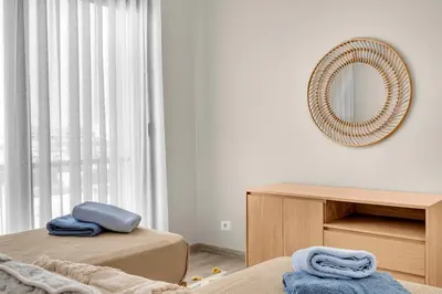 a bedroom with two beds and a mirror on the wall at Bright & Elegant 2BR Retreat - Kamaran El Gouna in Hurghada