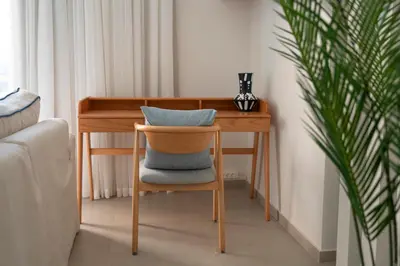 a wooden desk with a chair with a pillow on it at Bright & Elegant 2BR Retreat - Kamaran El Gouna in Hurghada