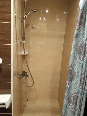 a bathroom with a shower with a blue shower curtain at فلورانزا خمسين f012 in Hurghada