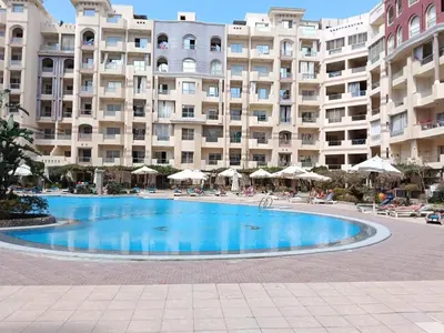 a swimming pool in front of a large apartment building at فلورانزا خمسين f012 in Hurghada