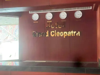 a wall with clocks on it with a sign on it at Grand Cleopatra Hotel-Luxor in Luxor