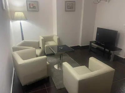a living room with white chairs and a television at Grand Cleopatra Hotel-Luxor in Luxor