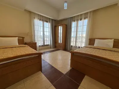 a bedroom with two beds and two windows at Tawaya Sahl Hasheesh 2 bedrooms in Hurghada