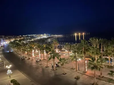 a street with palm trees and a bridge at night at Tawaya Sahl Hasheesh 2 bedrooms in Hurghada