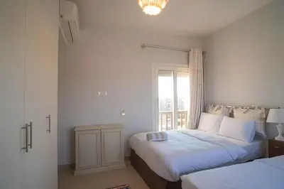 a bedroom with two beds and a window at Stunning 4BD Apartment Lagoon View-Gouna in Hurghada