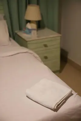 a bed with a white blanket and a night stand with a lamp at Stunning 4BD Apartment Lagoon View-Gouna in Hurghada
