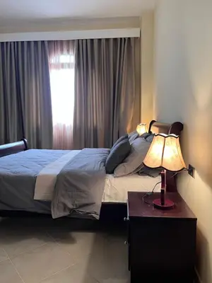 a bedroom with a bed with a lamp and a window at Gravity Apartment 410 beautiful apartment with view in structure Gravity Sahl Hasheesh -No Egyptian Passports in Hurghada