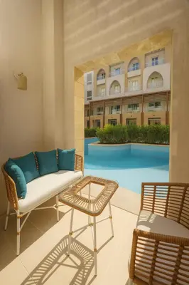 a living room with a couch and a table and a pool at Modern Sahl Hasheesh Pool Duplex - Beach & Wi-Fi in Hurghada