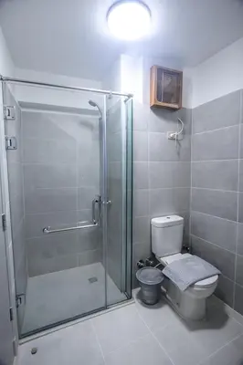 a bathroom with a toilet and a glass shower at Modern Sahl Hasheesh Pool Duplex - Beach & Wi-Fi in Hurghada