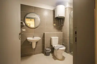 a bathroom with a toilet and a sink and a mirror at Modern Sahl Hasheesh Pool Duplex - Beach & Wi-Fi in Hurghada