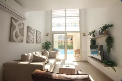 a living room with a couch and a large window at Modern Sahl Hasheesh Pool Duplex - Beach & Wi-Fi in Hurghada
